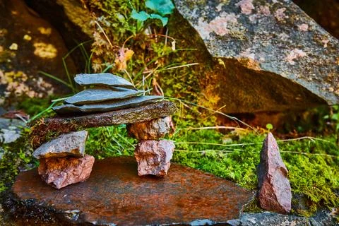 Cairn stone stack micro scene against mossy wet rocks 스톡 사진
