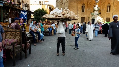 Cairo, Egypt - 2019-05-03 - Bizaare Street With Boy Carrying Huge Load of Bread Stock Footage 109424891