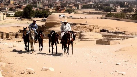 CAIRO, EGYPT - August 04, 2017: Two Egyptian men ride horses in desert Video stock 79606771