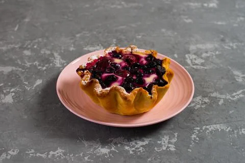 Cake basket with berries and cottage cheese on a pink saucer. Large tartlet w Stock Photos