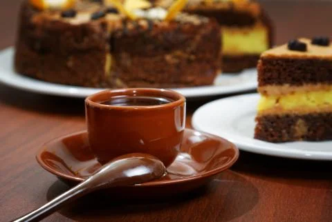 Cake with a brown cup of coffee on the table Stock Photos