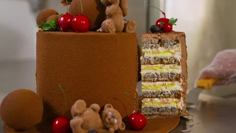 A cake with a brown hat on top and teddy bears on it Stock Footage 317456498