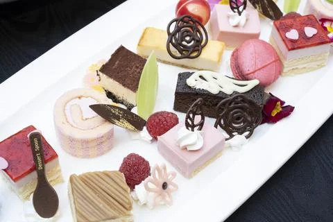 Cake buffet with various bite-sized cakes lined up Stock Photos