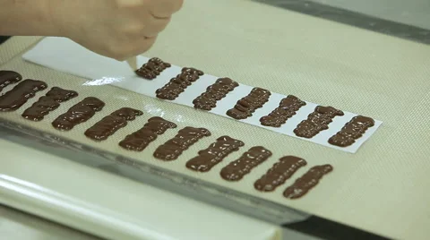 Cake decorating. Confectioner squeezes melted chocolate and makes parts for cake Stock Footage 50475718
