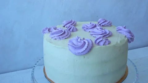 Cake decorating process. A woman squeezes cream onto a cake from a pastry bag. Stock Footage 168644349