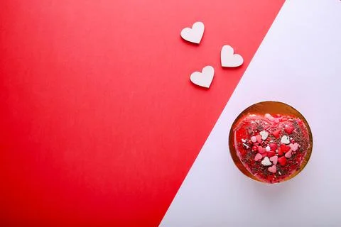Cake in the form of a heart on a red background. Valentine's Day. Stock Photos