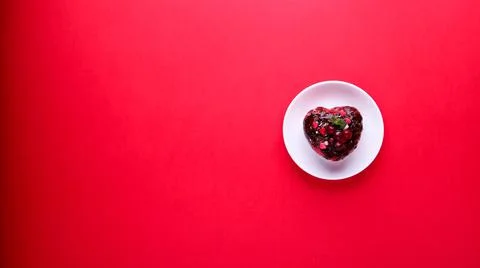 Cake in the form of a heart on a red background. Valentine's Day. Stock Photos