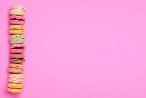 Cake macaron or macaroon on pink background from above, colorful cookies. Stock Photos