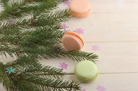 Cake macarons with Christmas tree branches and snowflakes on wooden backgroun Stock Photos