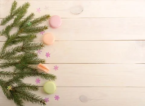 Cake macarons with Christmas tree branches and snowflakes on wooden backgroun Stock Photos