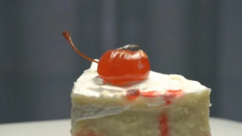 Cake piece with red cherry on top and black chocolate close Stock Footage 122250854