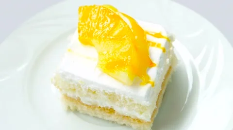 Cake with pineapple closeup rotates on white plate Stock Footage 54227118