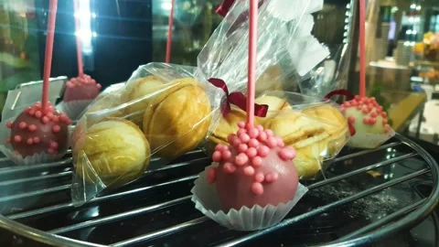 Cake pops on a stick and nuts condensed milk on a glass spinning display case Video stock 313614530