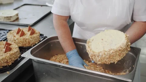 Cake preparation process with almond coating in an industrial bakery Stock Footage 322512176