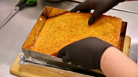 Cake preparation process with hands removing and adjusting baked layer in pan Stock Footage 333864235