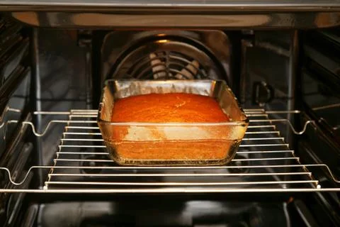 Cake in rectangular glass form is baked in the oven Stockfoto's
