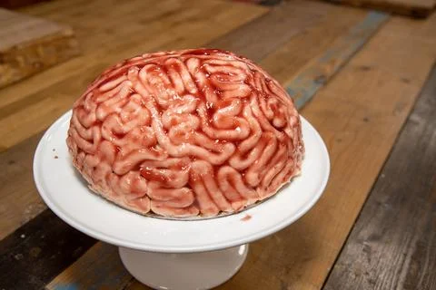 A cake in the shape of a brain with strawberry source brushed on it to make.. Stock Photos