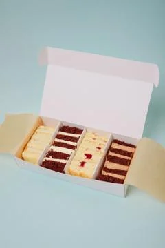 Cake slices in a box on a light background Stock Photos