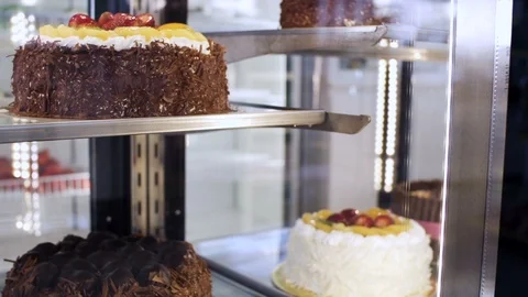 Cakes and desserts inside a display at confectionery shop Video stock 121963403
