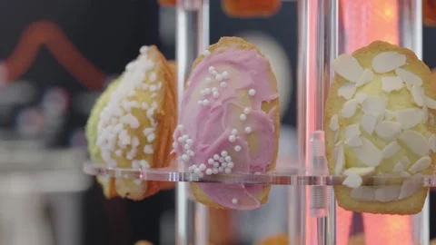 Cakes with different icing rotating on a vertical display stand close up shot. Video stock 304316990