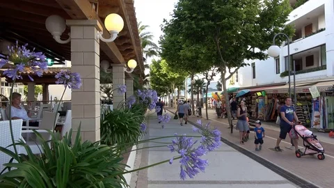 Cala Millor Mallorca Spain: Tourists walking next to shops and bars in the Video stock 81069115
