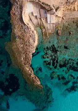 Cala Xarraca beach overhead view. Fisherman's huts in this hidden place. Stock Photos