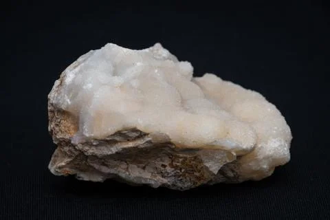 Calc-sinter white gemstone formed on an usual piece of bed rock Stock Photos
