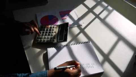 Calculating and planning in a sunlit workspace Stock Footage 320724149