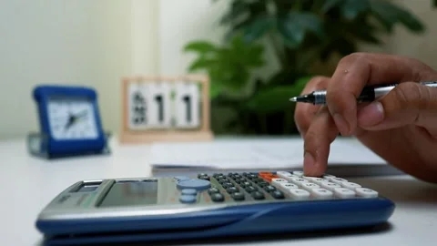 Calculating Finances with Calendar in Background Stock Footage 320724921