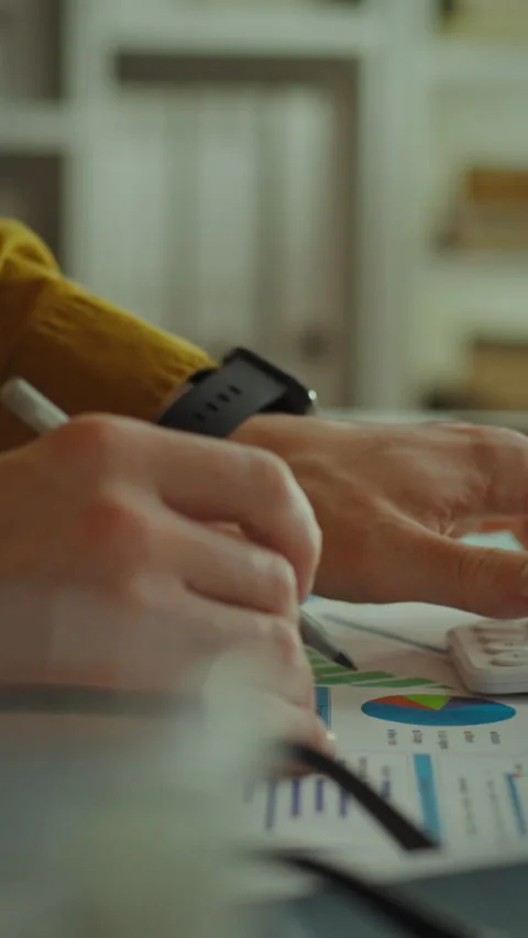 Calculating financial data with a calculator in a modern office setting Stock Footage 331536207