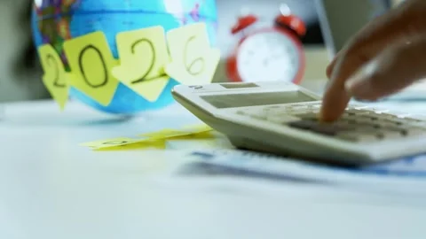 Calculating Future Plans for 2026, Close-up of a hand using a calculator wi.. Stock Footage 321223982