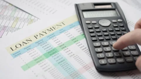 Calculating Loan Payment With Calculator Over Documents Stock Footage 255992224