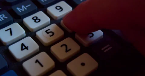 Calculation using a calculator. A finger presses the plastic buttons of a modern Stock Footage 318157992