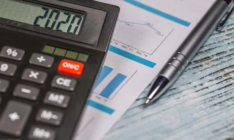 Calculator with 2020 digits ,pen and business document lie on the table Stock Photos