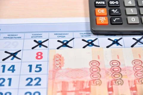 Calculator and banknotes of five thousand rubles are on the calendar with hol Stock Photos