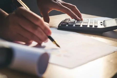Calculator and Financial data analyzing hand writing and counting in office.. Stock Photos