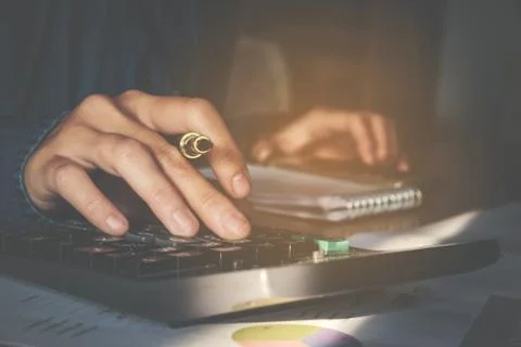 Calculator and Financial data analyzing hand writing and counting in office.. Stock Photos
