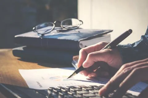 Calculator and Financial data analyzing hand writing and counting in office.. Foto stock