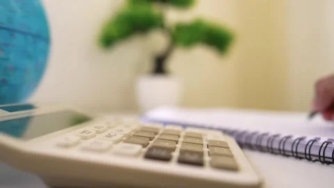 Calculator and Notebook on Desk, Close-up of a calculator, notebook, and gl.. Stock Footage 317737122