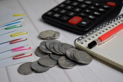 Calculator and the stack of coint isolated on office desk. calculating salary Foto stock