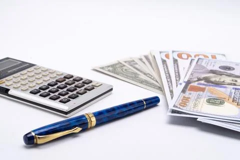 Calculator, Blue Pen, and Stack of Hundred Dollar Bills on White Background. 写真素材