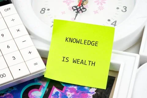 A calculator, a clock, and a sticky note emphasize the importance of knowledg Stock Photos