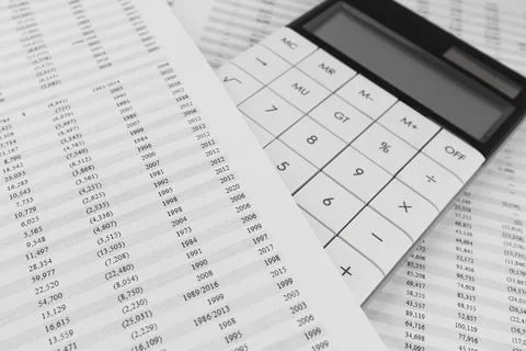 Calculator on financial documents covered by a sheet with statement. Stock Photos