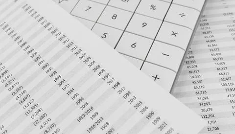 Calculator on financial documents covered by a sheet with statement. Stock Photos
