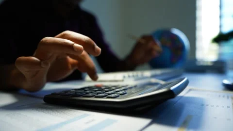 Calculator on financial documents in office, Close-up of a person using a c.. Video stock 346460997