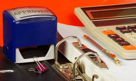 The calculator is on the folder with the documents, along with the stamp an.. Foto stock