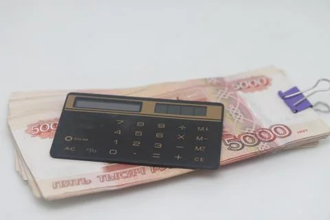The calculator lies on a stack of Russian banknotes, accounting for finances. Stock Photos