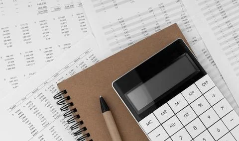 Calculator with notebook on financial statement. Stock Photos