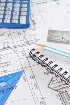 Calculator, notepad and drawing tools arranged on plans Stock Photos