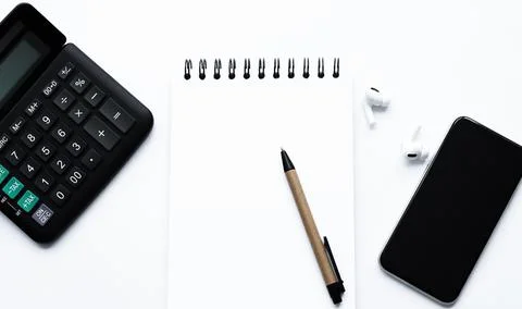 Calculator, notepad, spiral notebook, pen, AirPods, headphones, on white Stock-Fotos